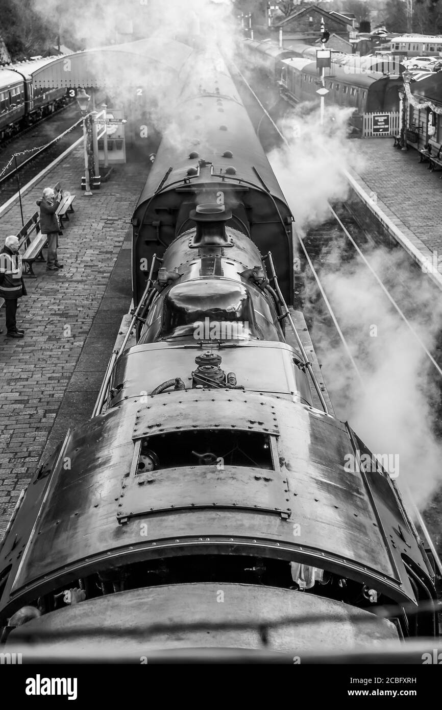 Atmospheric, monochrome, overhead view of vintage UK steam train waiting alongside platform, Bewdley station, Severn Valley Railway heritage line, UK. Stock Photo