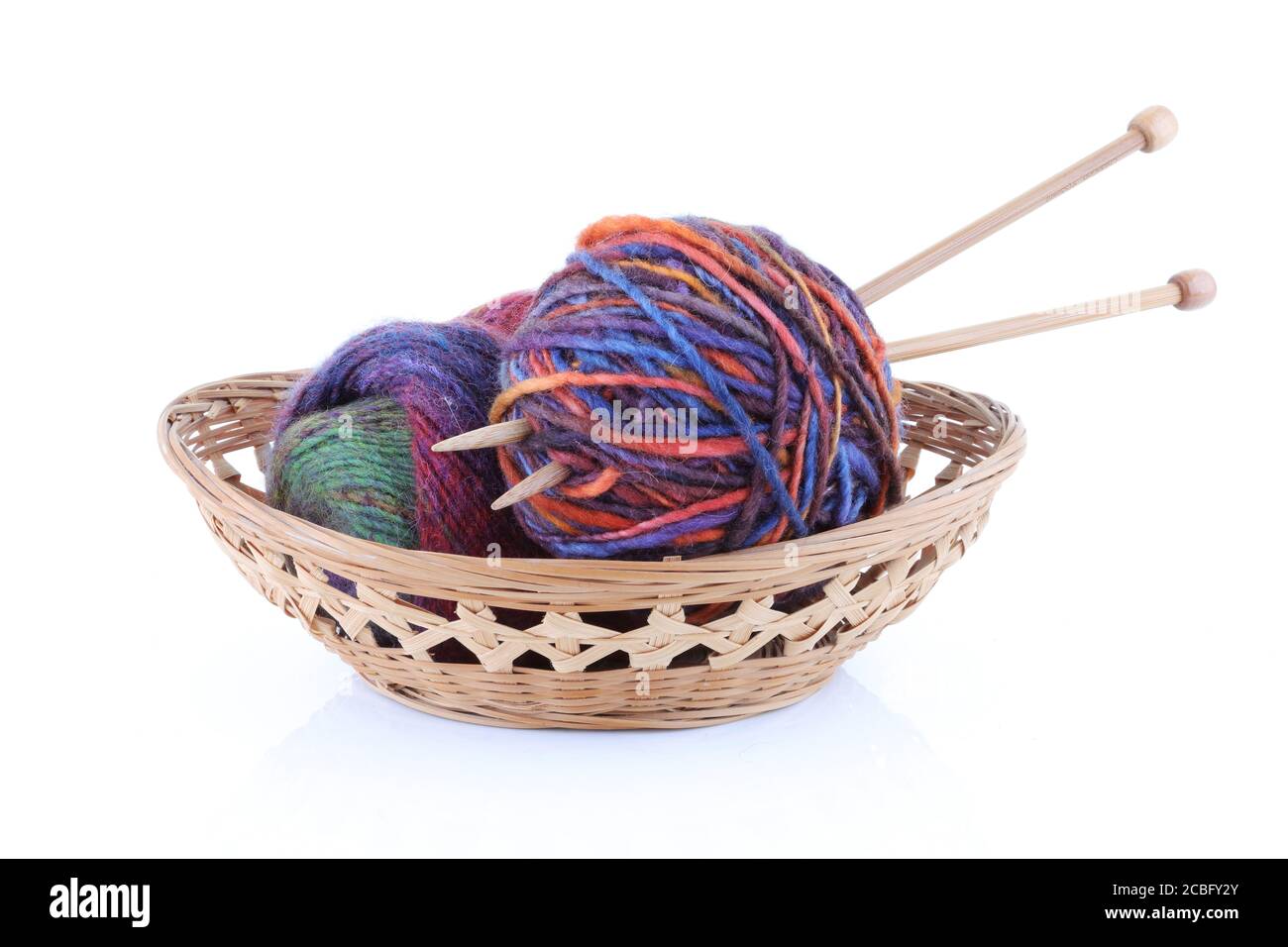 Basket with two balls of wool and knitting needles Stock Photo
