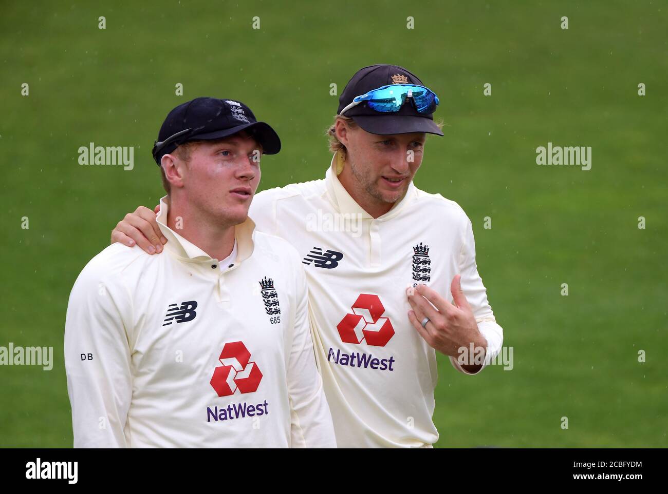 England's Joe Root (right) and Dom Bess walk off the pitch as rain stops play during day one of the Second Test match at the Ageas Bowl, Southampton. Stock Photo