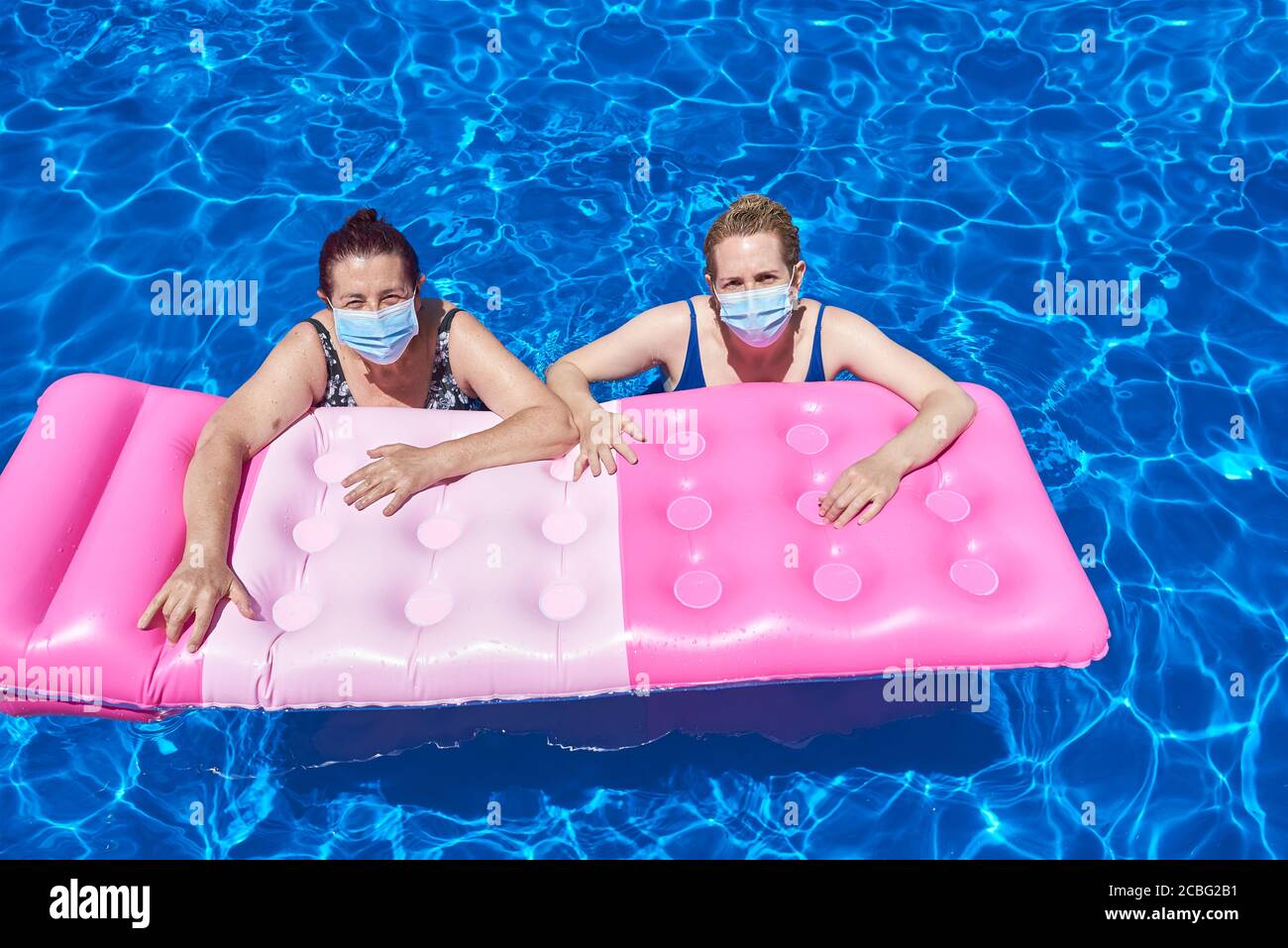 Two women bathe in a pool with a mask. Stock Photo