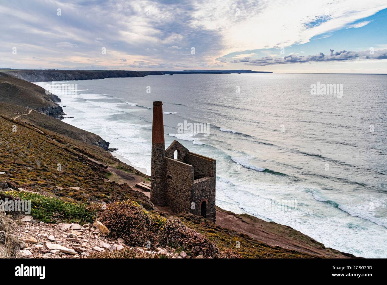 Cornish Coastline View with Chapel Porth Tin Mine, Atlantic Surf and Moody Sky. Saint Agnes, Cornwall, England. Stock Photo