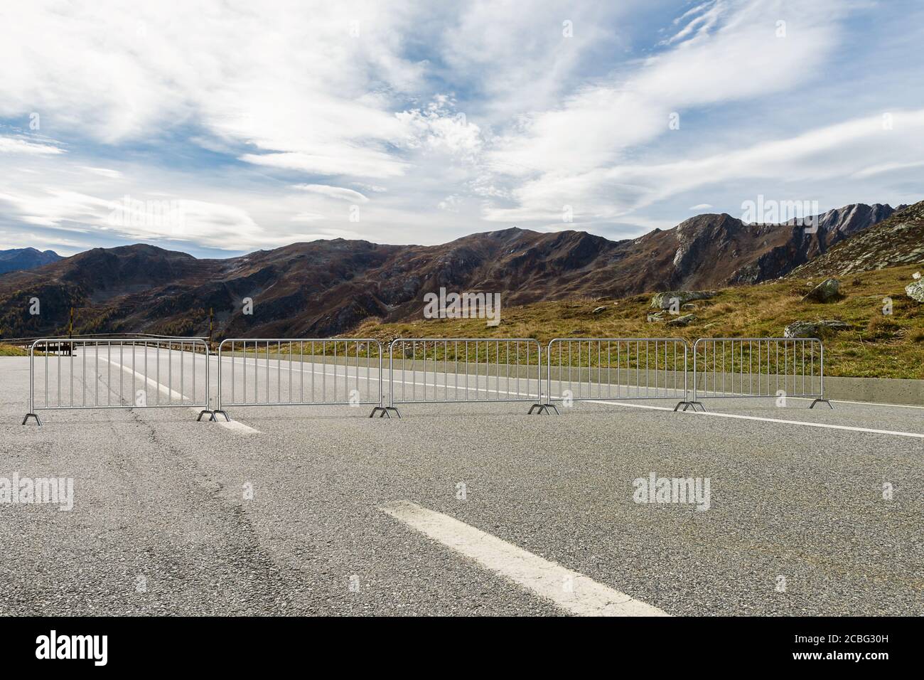 Steel barricades set across the road block the passage - a view of the mountains in the background - 3d illustration Stock Photo