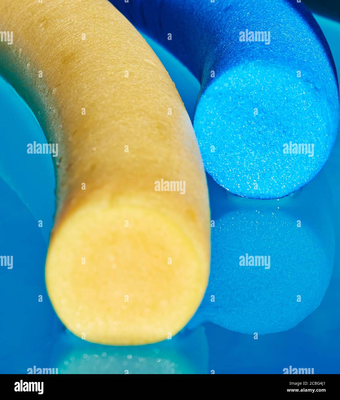 A yellow and a blue pool noodle in a swimming pool with reflections in the  water Stock Photo - Alamy