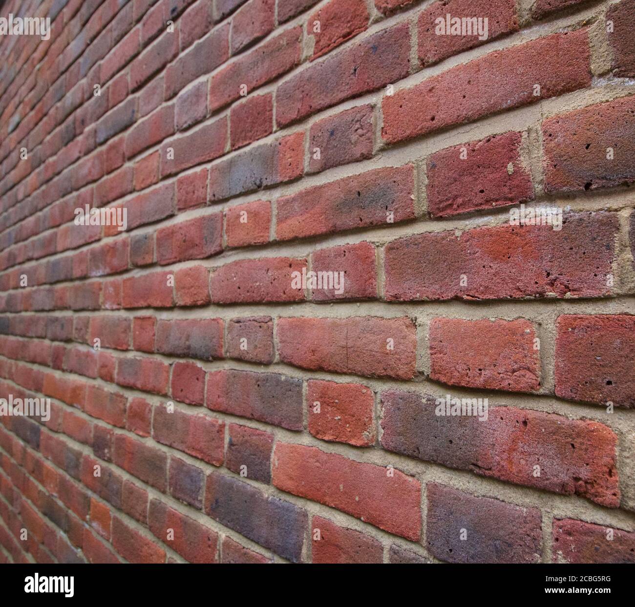 Neat background brick wall leading to vanishing point in the distance Stock Photo