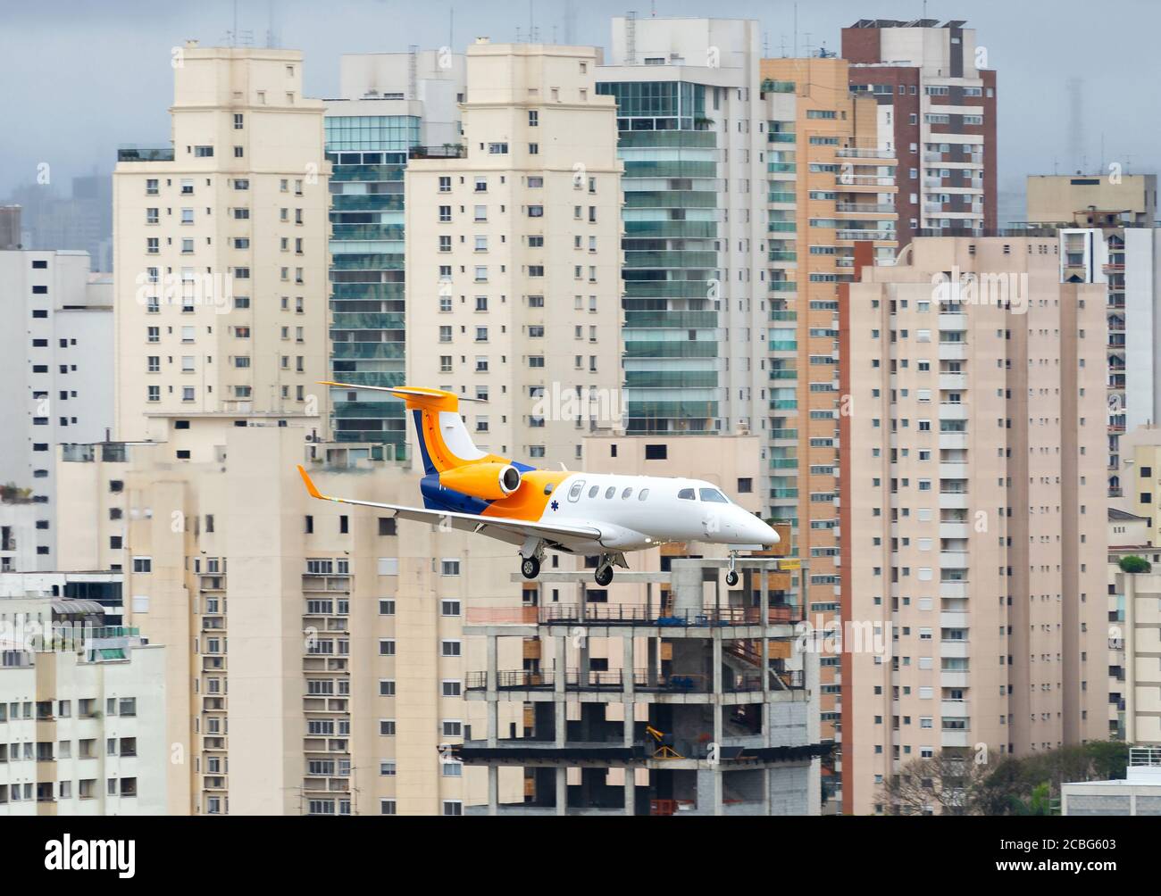 Embraer Phenom 300 landing in Congonhas Airport with Sao Paulo buildings behind. Business jet aircraft at centrally located airport in Brazil. Stock Photo