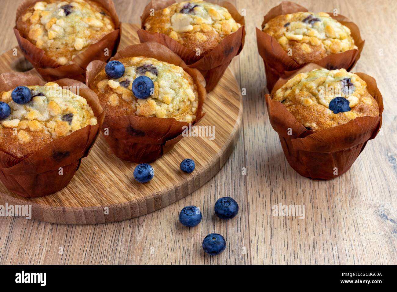 blueberry muffins with scattered berries on the wooden table Stock Photo