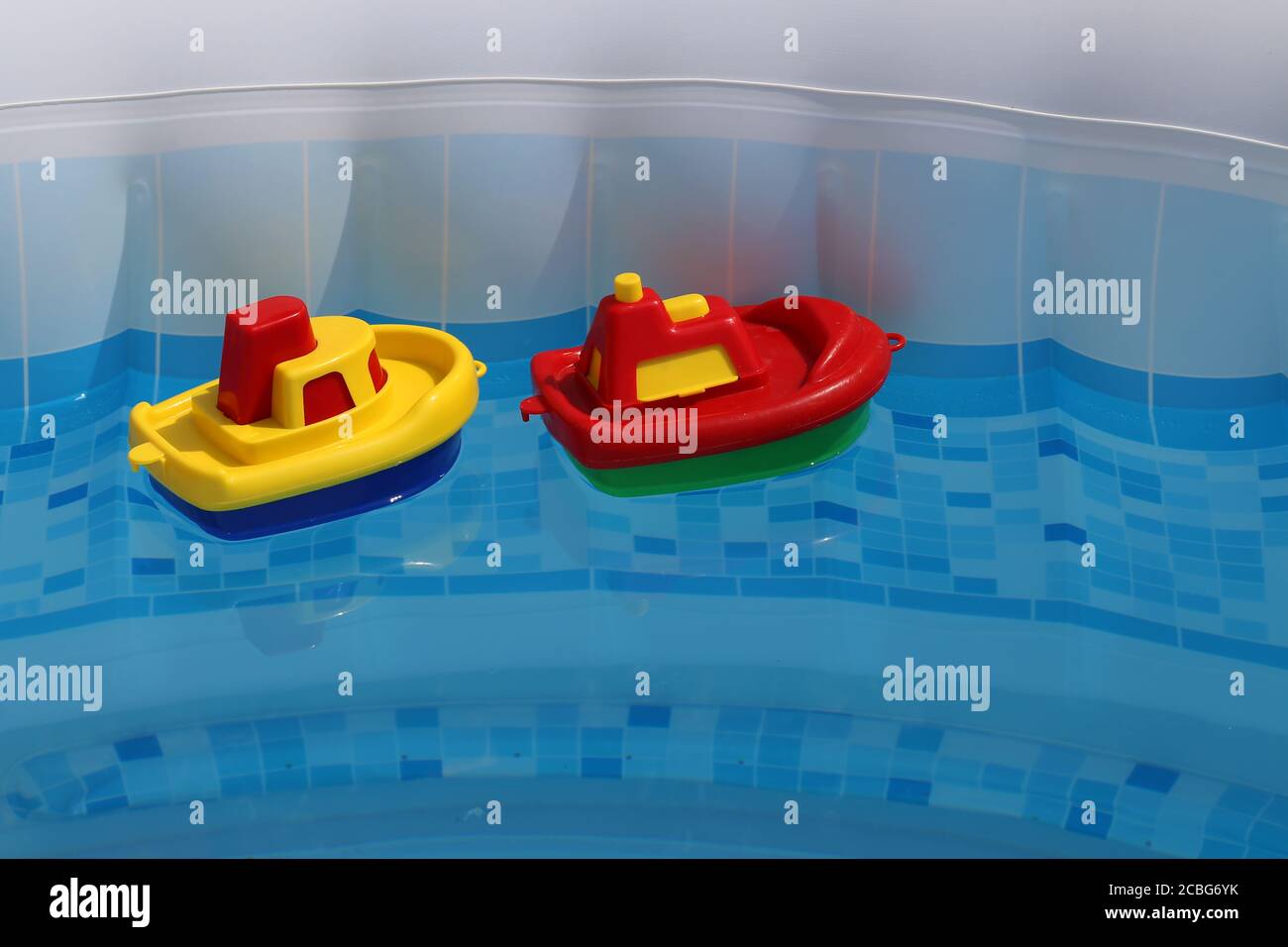 Bright colored toy boats float in the home pool Stock Photo - Alamy