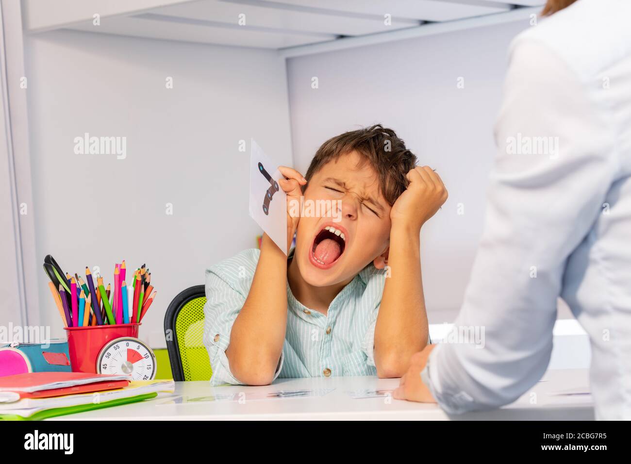 Autistic child tear hairs and scream expressing negative emotions while ...