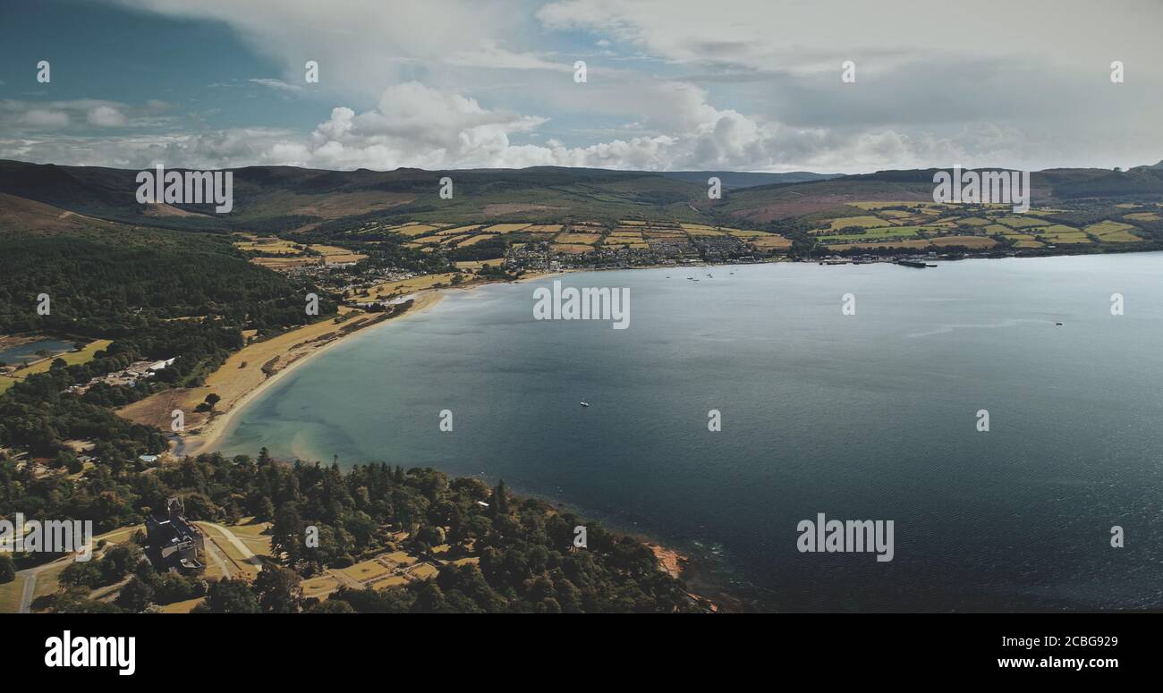 Scotland's ocean, Brodick Harbour aerial view: ferry, ships, boats. Majestic seascape of pier at Firth-of-Clyde Gulf. Nature landscape of wide forests Stock Photo