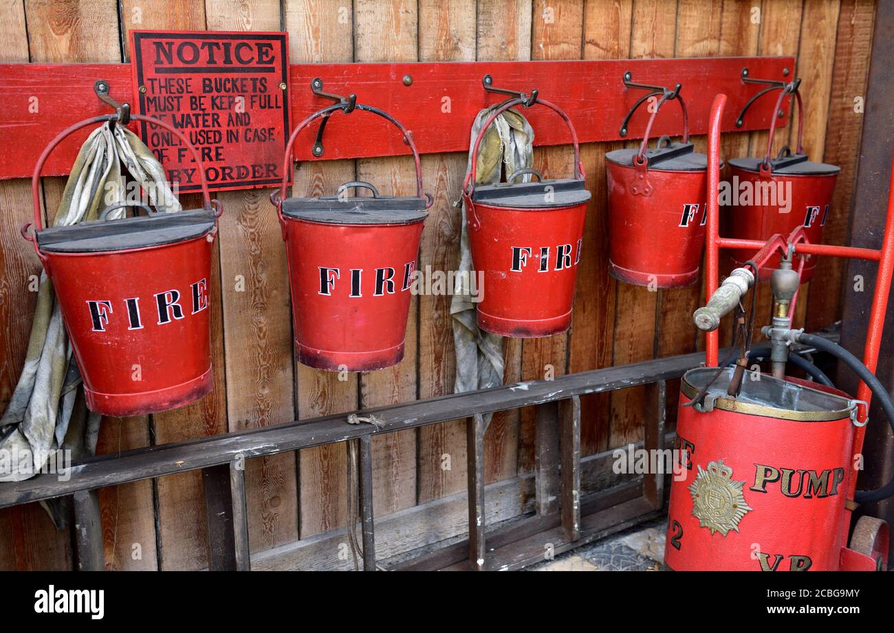 Old historic fire fighting buckets and pump re-enactment exhibit SS Great Britain museum, Bristol, UK Stock Photo