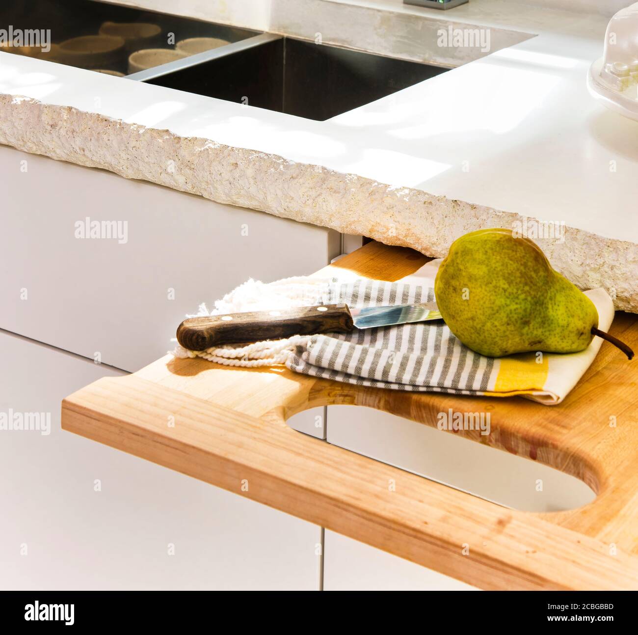 Contemporary White Kitchen with Concrete Countertop, Pull-Out Cutting Board Stock Photo