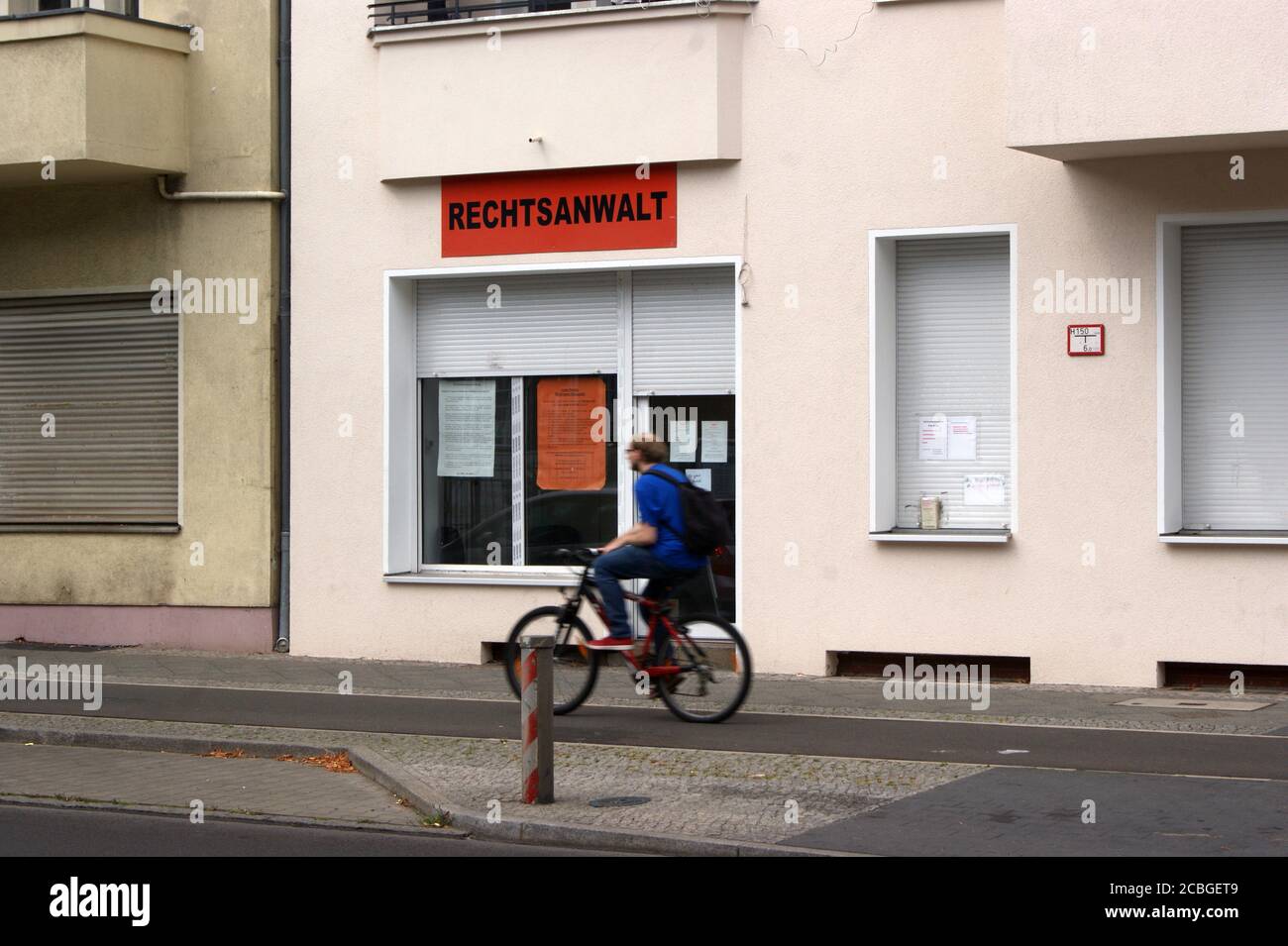 Symbolfoto: ein Radfahrer vor einer Anwaltskanzlei; Symbolic photo: a cyclist in front of a law firm; Stock Photo