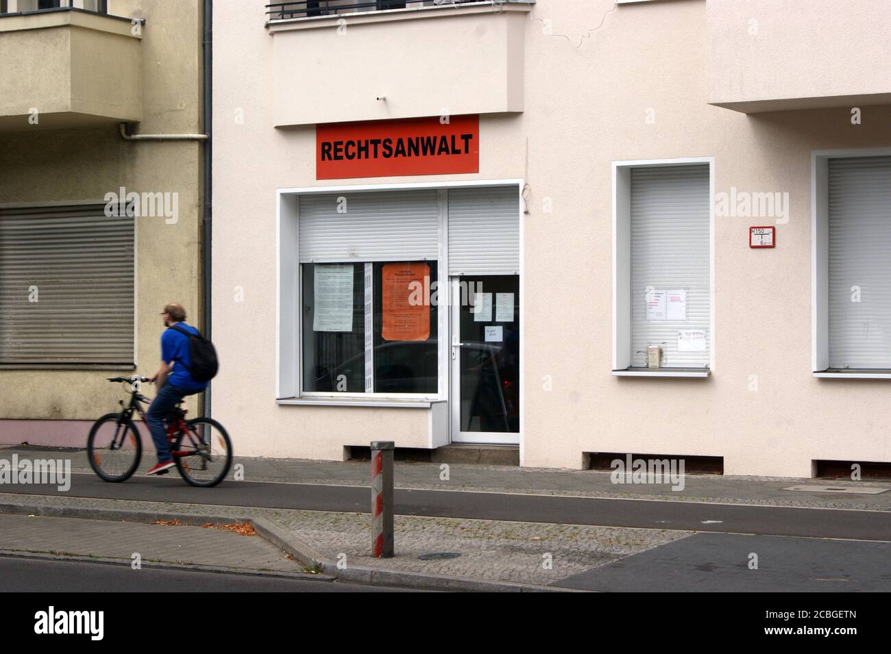 Symbolfoto: ein Radfahrer vor einer Anwaltskanzlei; Symbolic photo: a cyclist in front of a law firm; Stock Photo