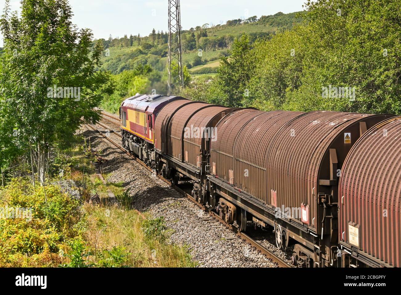 Pontyclun, Wales - August 2020: Heavy diesel locomotive pulling a freight train with covered wagons Stock Photo