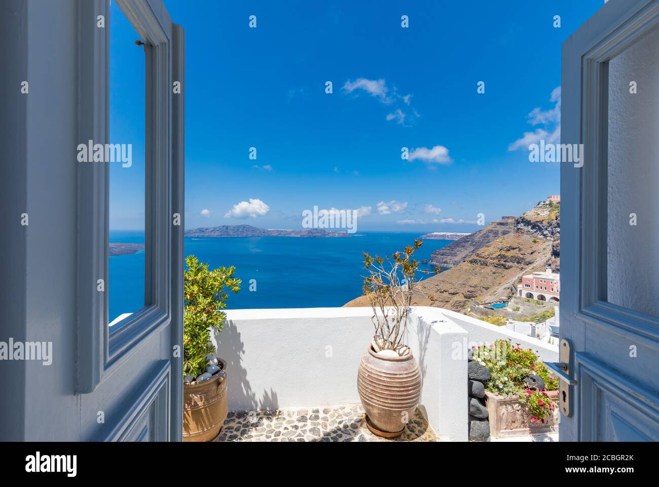 Santorini Island, Greece. Traditional Greek door with a great view. Amazing seascape over cliff with wooden door and traditional white architecture Stock Photo