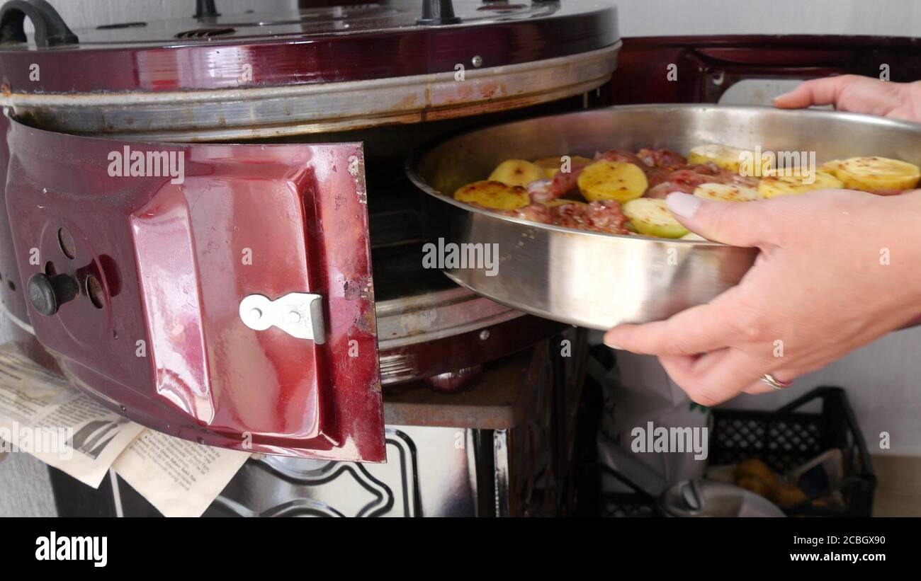 The woman puts the uncooked tray into oven Stock Photo Alamy