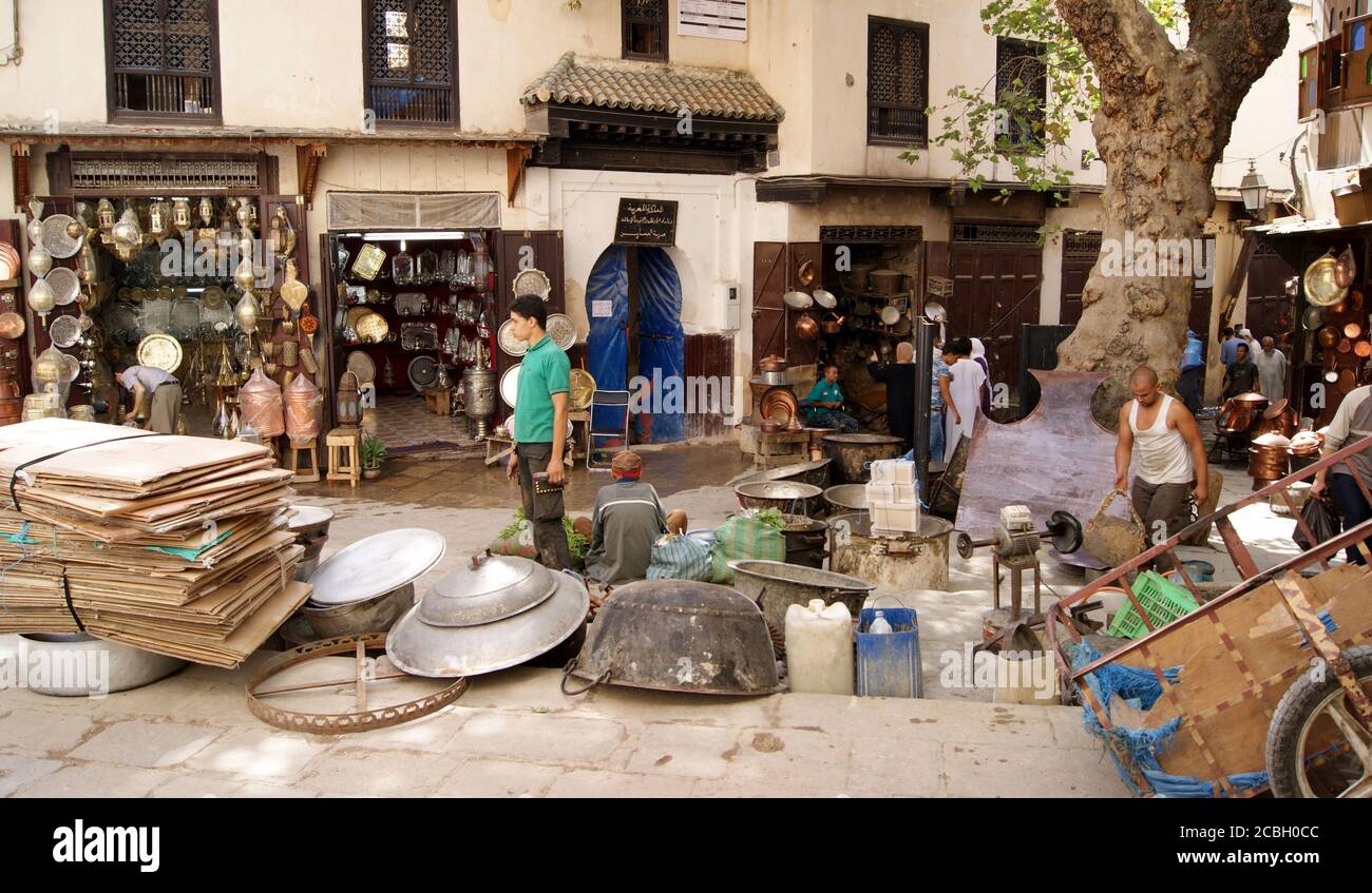 Displayed metalworks line Place Seffarine Square in Fez, Morocco known for its coppersmiths and metalworkers. This souk is one of the many specialized areas found throughout the Fez Old Town, also known as the Fez Medina. Stock Photo