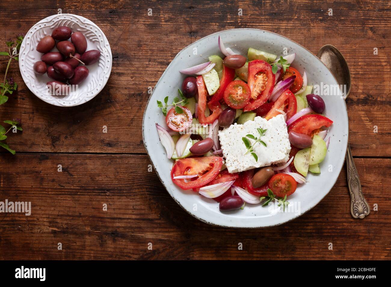 A fresh traditional greek salad horiatiki choriatiki with feta cheese, tomatoes, cucumber, onion and kalamata olives. The salad is seen from above on Stock Photo
