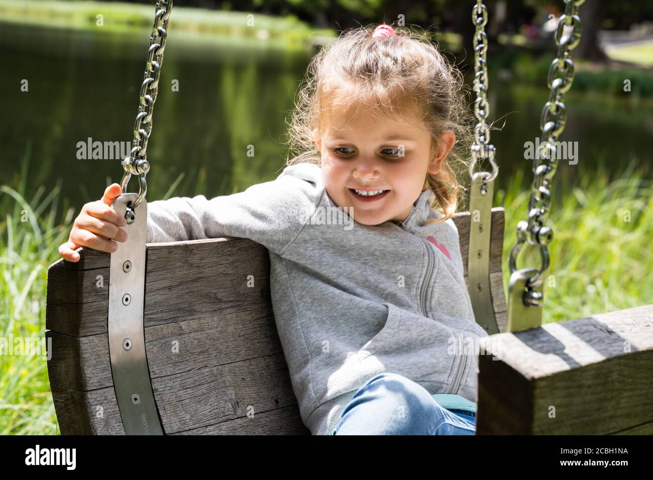 Happy Little Girl On Playground In Summer Stock Photo - Alamy