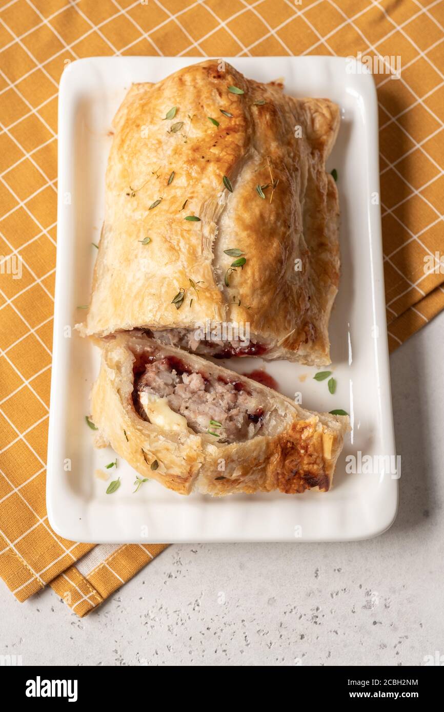 Baked pork turkey sausage rolls with brie cheese and cranberry sauce in