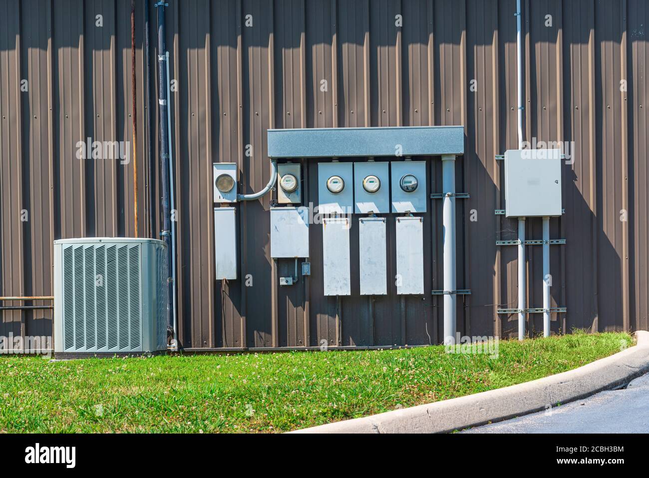 Horizontal shot of an air conditioner and electric meters outside of an office complex. Stock Photo