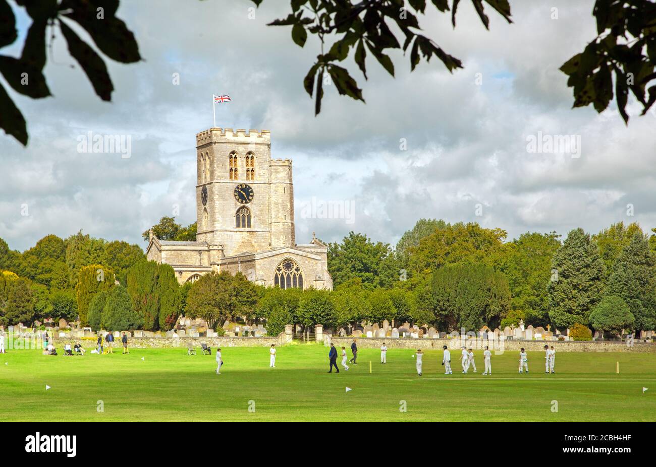 Junior youth cricket match on the picturesque church meadow the home of Thame cricket club Oxfordshire England with St Mary's church in the background Stock Photo