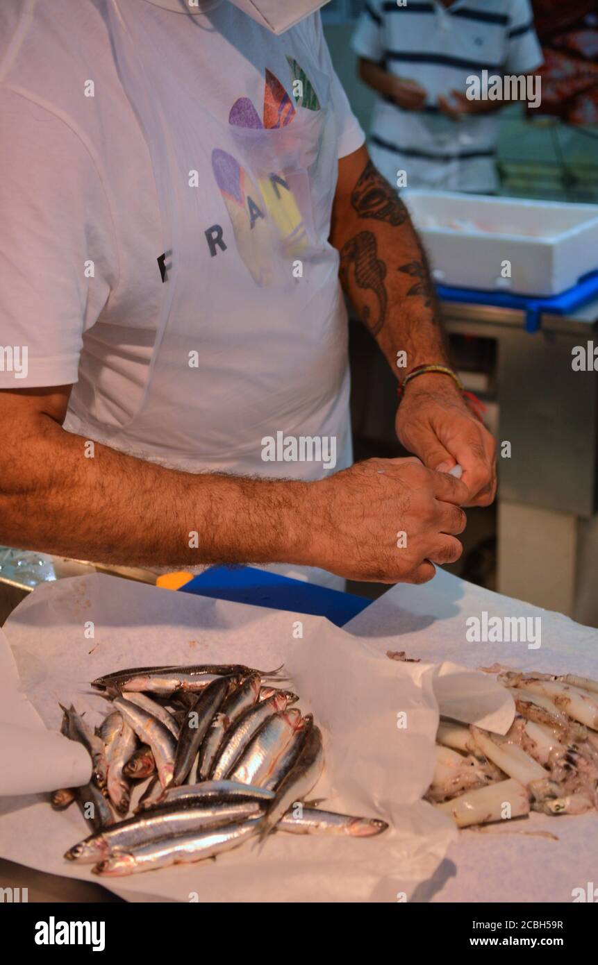 Italy - August 2020 at the fish market butcher works cleaning and ...