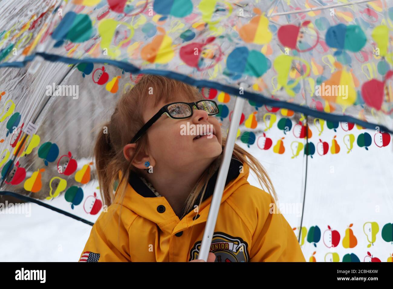 Child under umbrella in snow Stock Photo