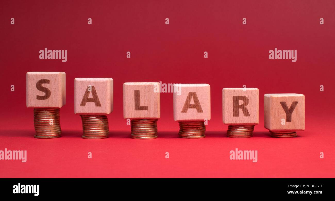 Salary word made with wooden blocks with stacked coins: Salary reduction Stock Photo
