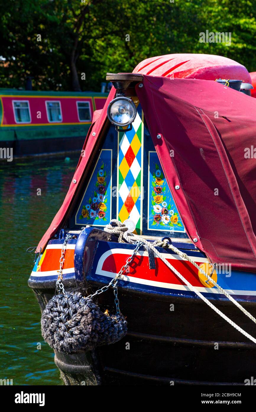 A houseboat painted in a colourful folk roses & castles motif, Regents Canal, London, UK Stock Photo