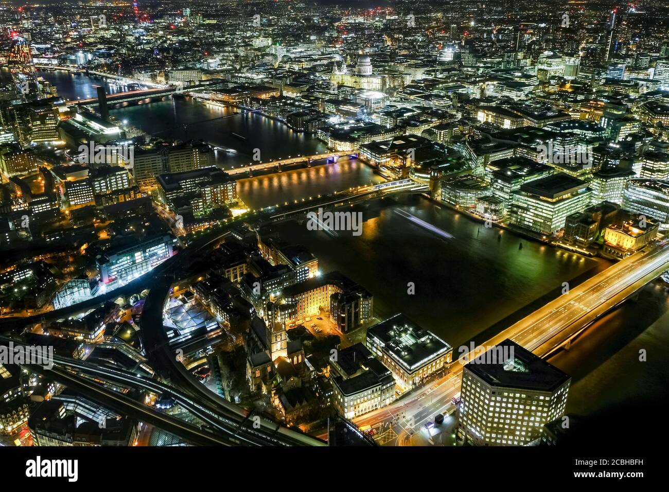 Night-time aerial view of Central London and the River Thames.  London Bridge, Millennium Bridge and Southwark Bridge are all visible. Stock Photo
