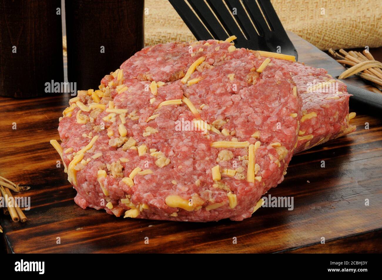 Ground beef patties with cheddar cheese and bacon bits mixed in with it Stock Photo