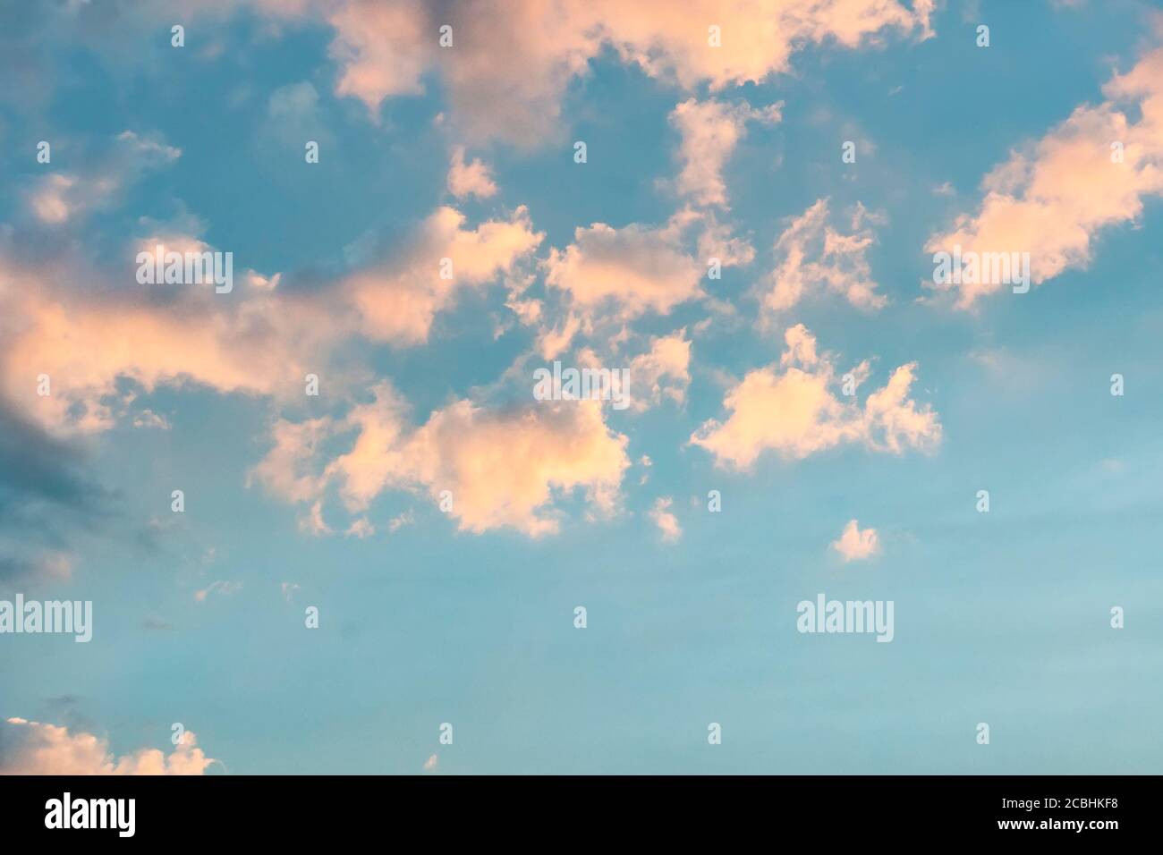 Pink clouds against a blue sky at sunset. Stock Photo
