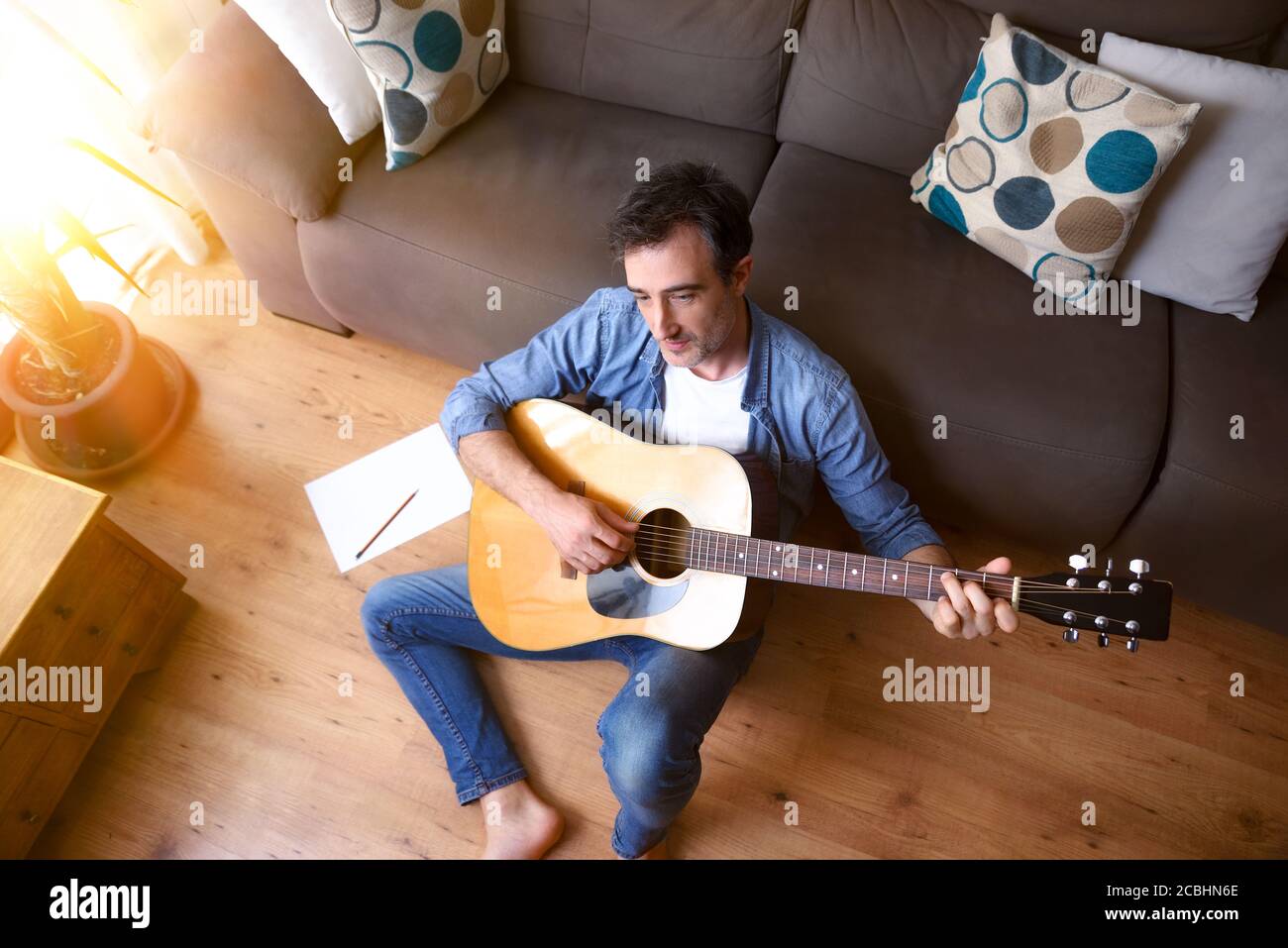 Guitar leaning near fireplace behind chaise in living room Stock  Illustration