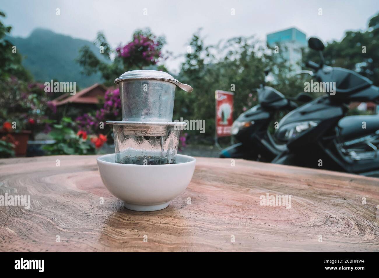 Vietnam coffee style, Drip coffee, Dropping water on Ground coffee in stainless filter with wooden table background. top view and copy space Stock Photo