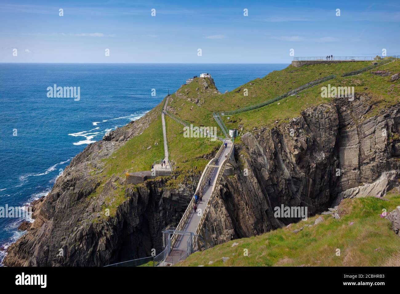 View of the bridge between the two cliffs of the Mizen Islands Head Signal Station and the high vantage point. Stock Photo
