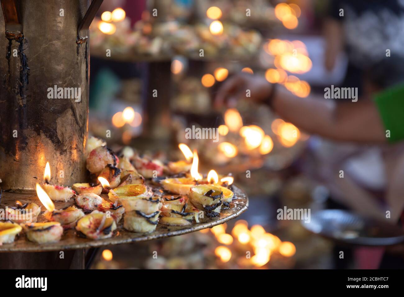 devotees lighting lemon lamps as a hindu ritual Stock Photo Alamy