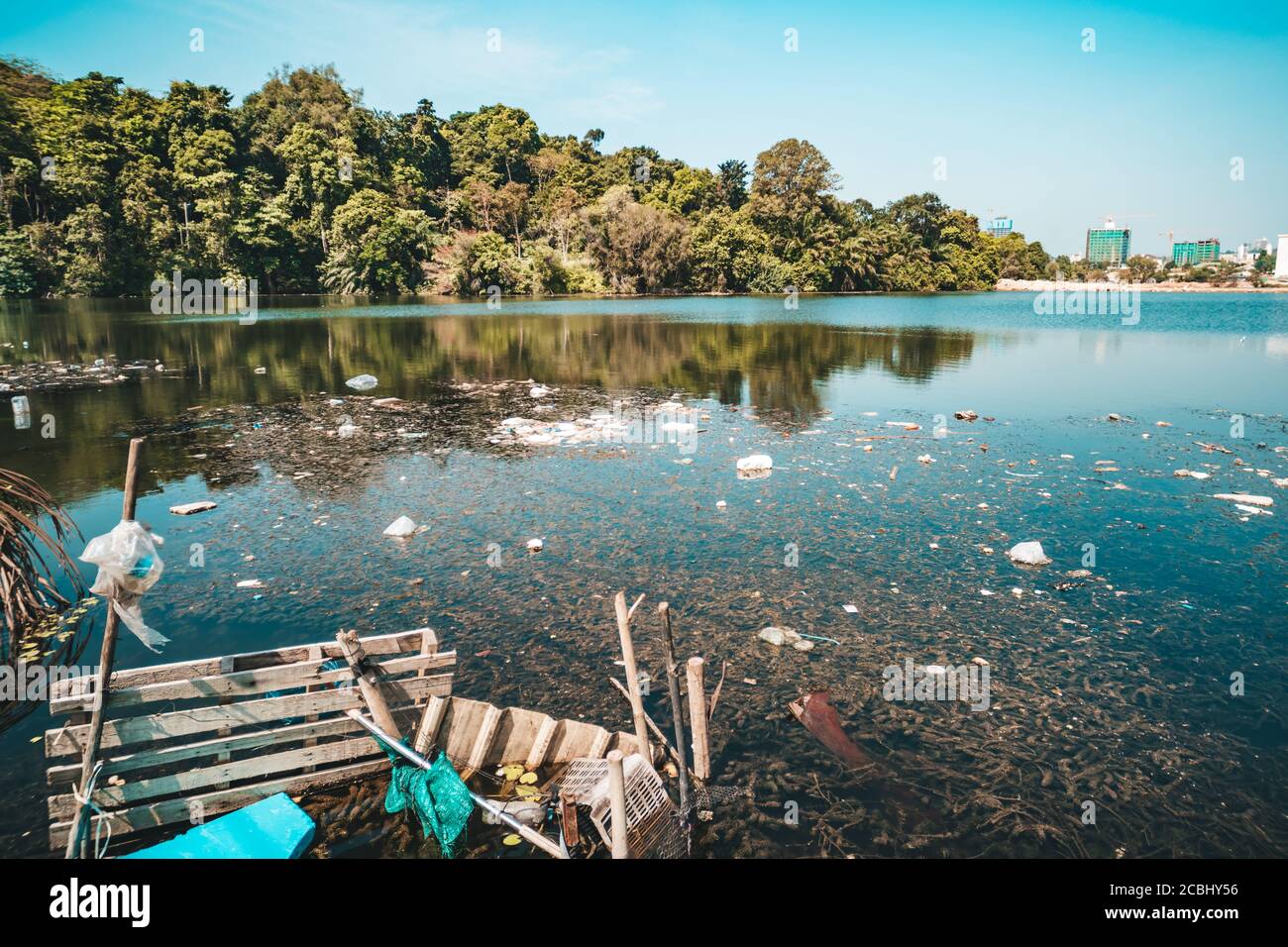 City dump in the pond in Park. Garbage lies in the water on one of the urban landscape. plastic bottles were thrown into the water. Stock Photo