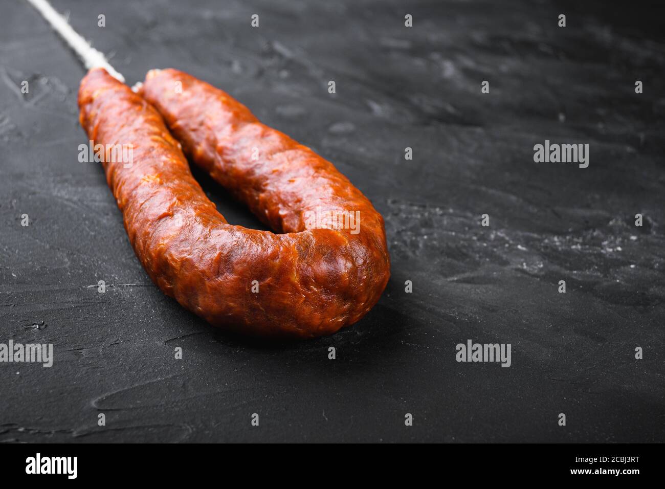 Spanish pork chorizo sausages on black background with space for text