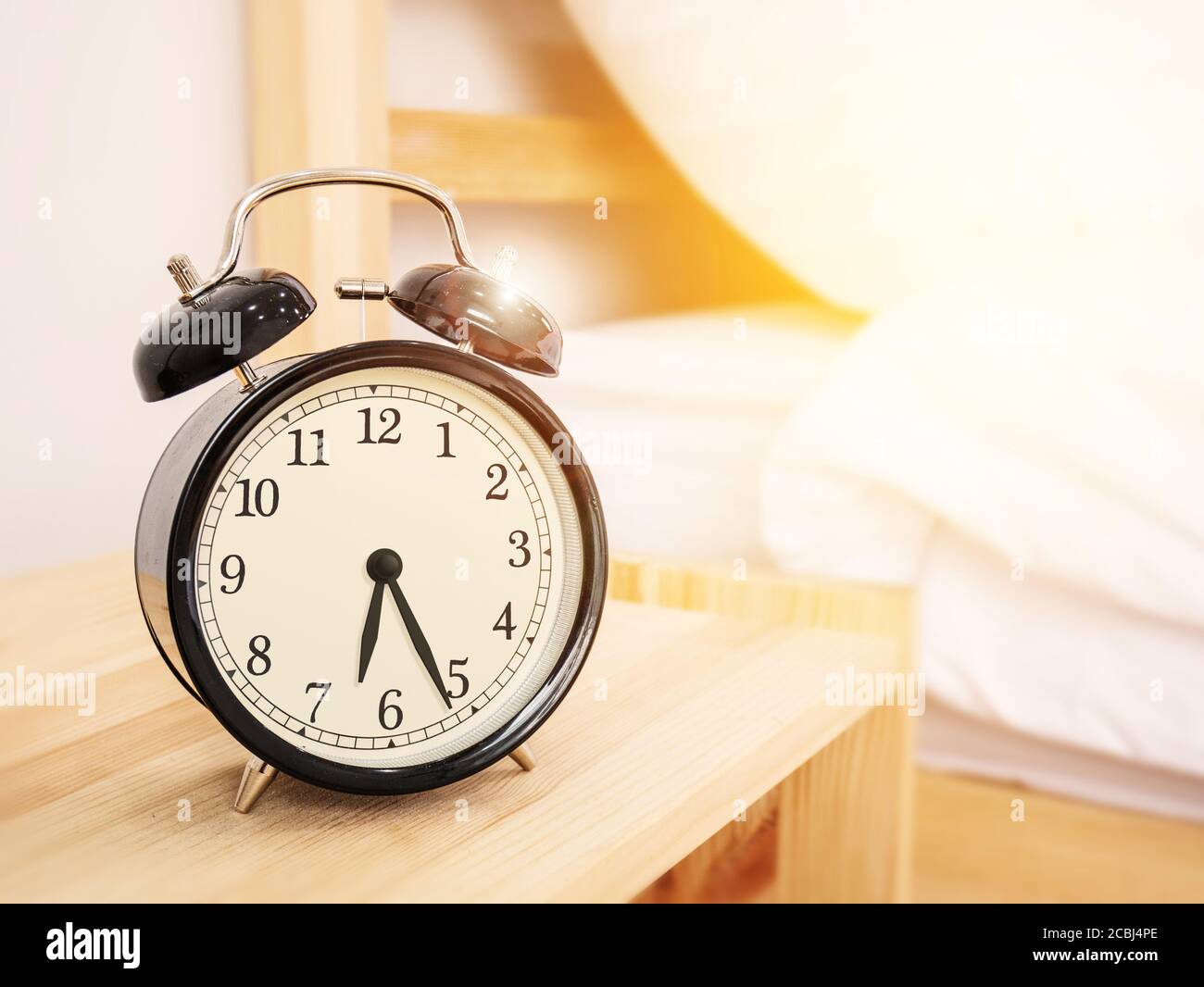 morning time background, retro alarm clock near the bed at home. Stock Photo