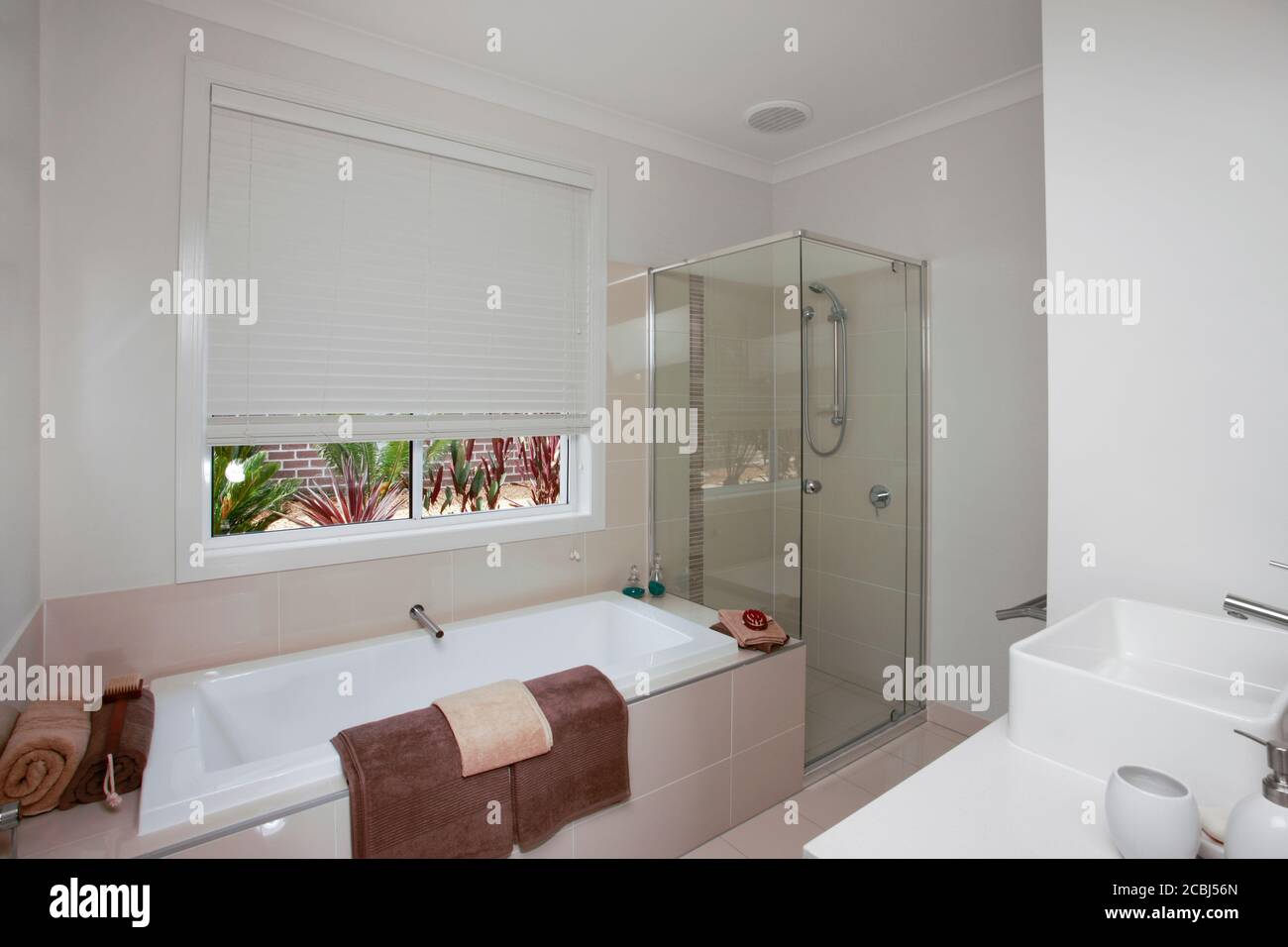 A white bathroom with brown bath towels Stock Photo Alamy