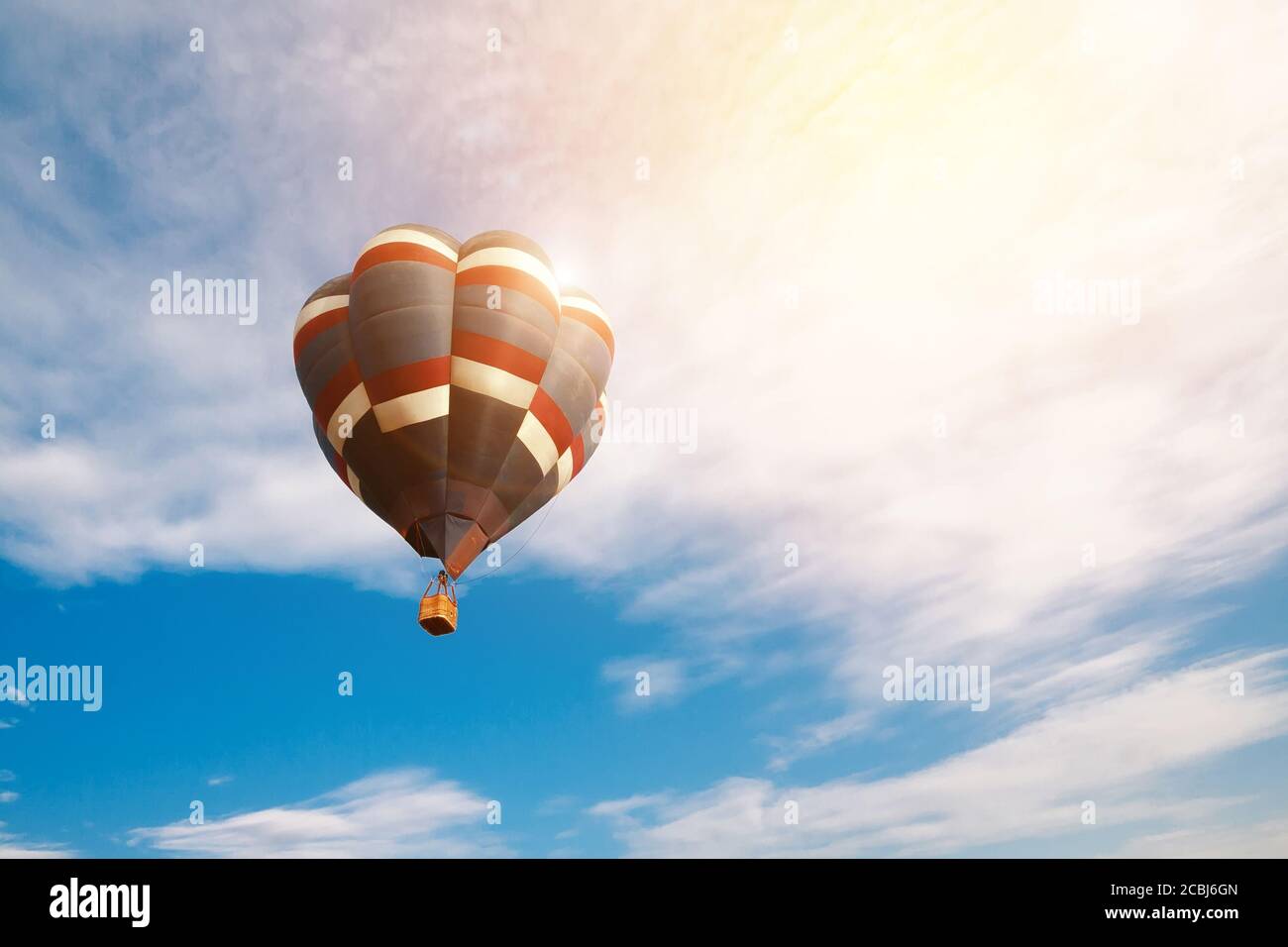 Travel and tourism concept. Colorful hot air balloon flying at sunrise with cloudy blue sky background Stock Photo