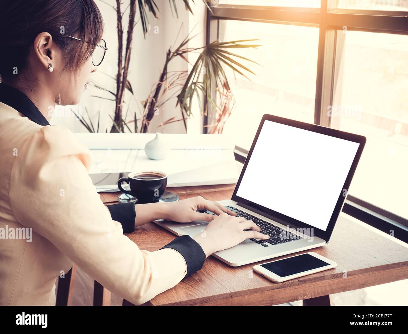 Technology concept : Young Asian architect manager working with creative project in modern office. Contemporary blank white screen notebook on table Stock Photo
