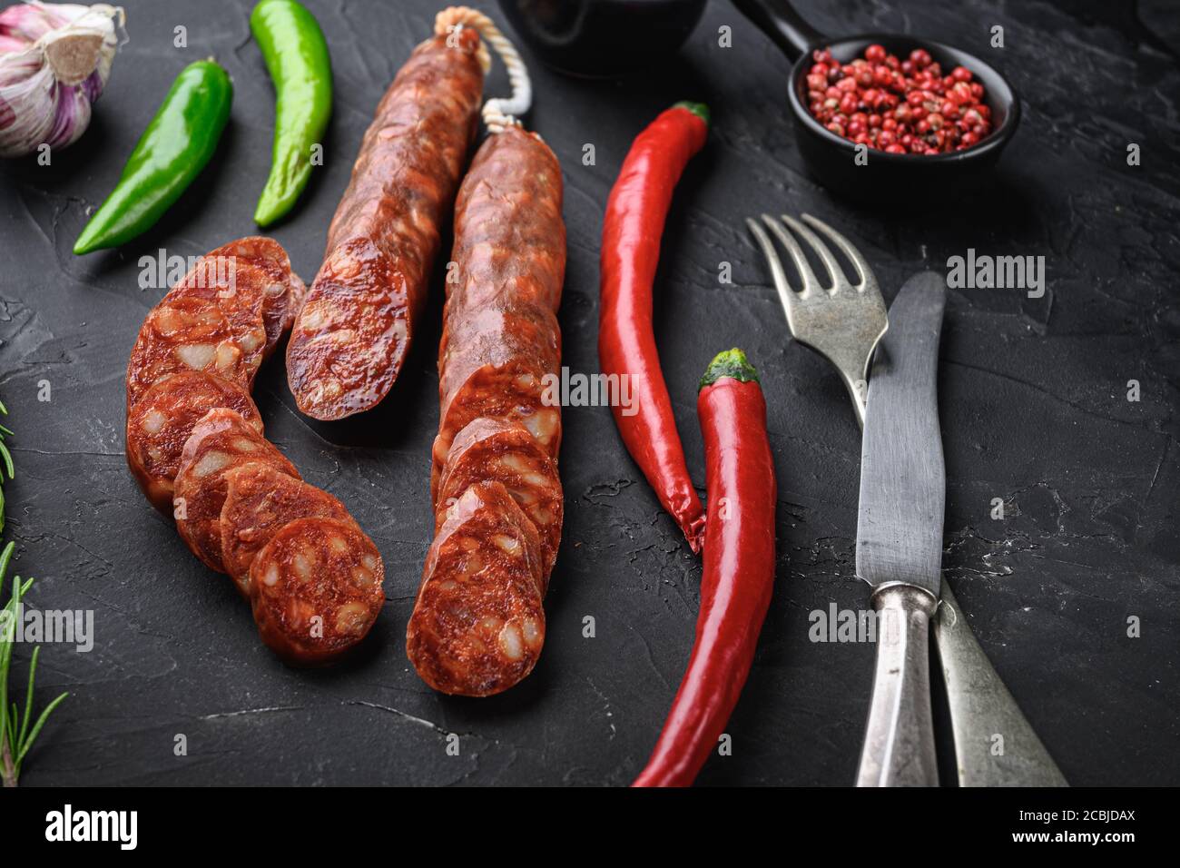 Spanish chorizo sausage slices with herbs and spices on balck ...