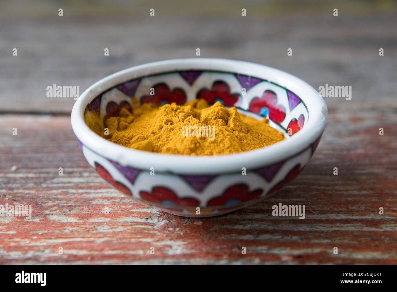 Turmeric yellow powder bowl on wood, Asia spice Stock Photo