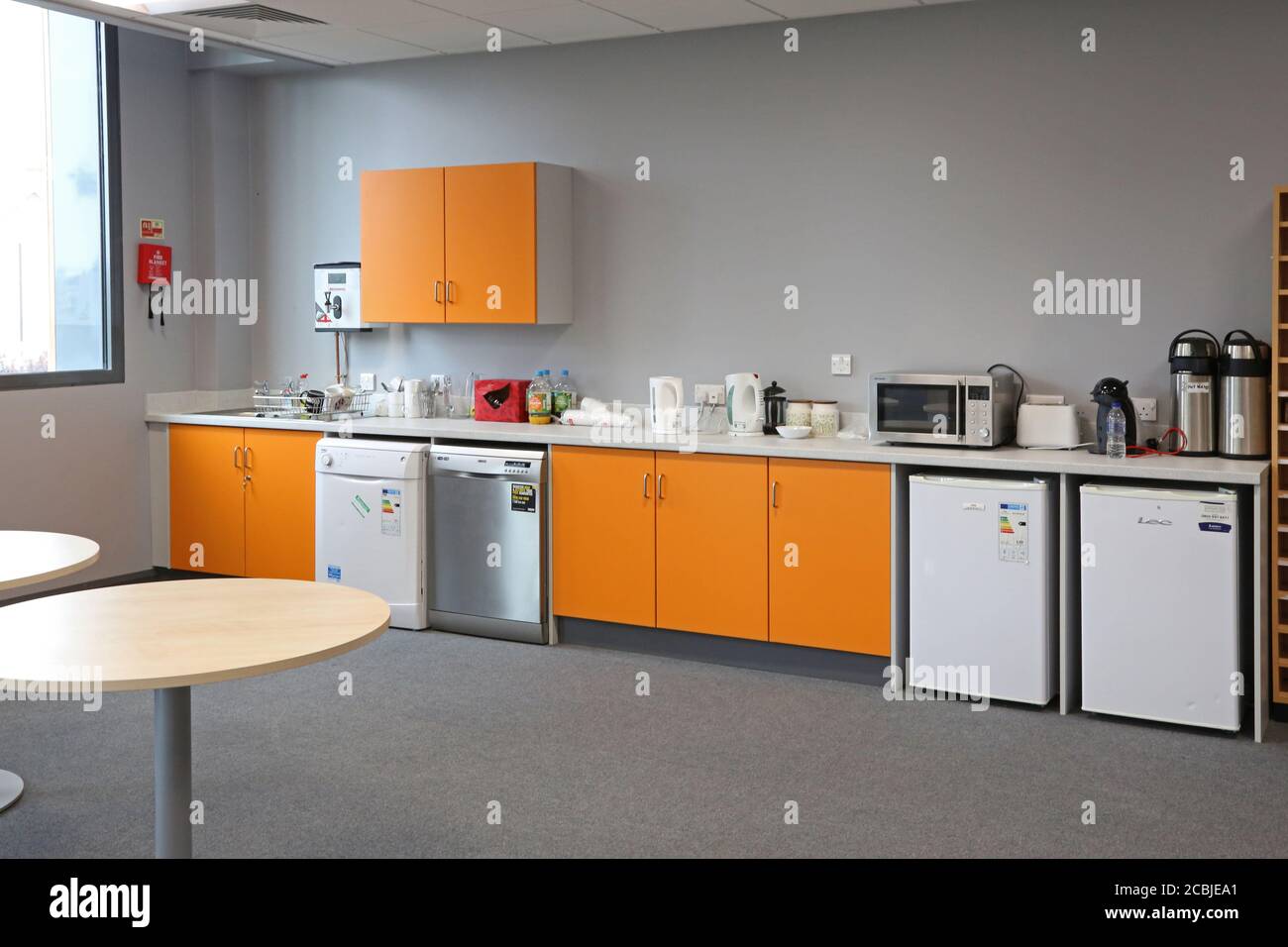 Staff room in a newly completed London secondary school. Shows kitchen area with fridges and dishwashers plus seating area in foreground. Stock Photo