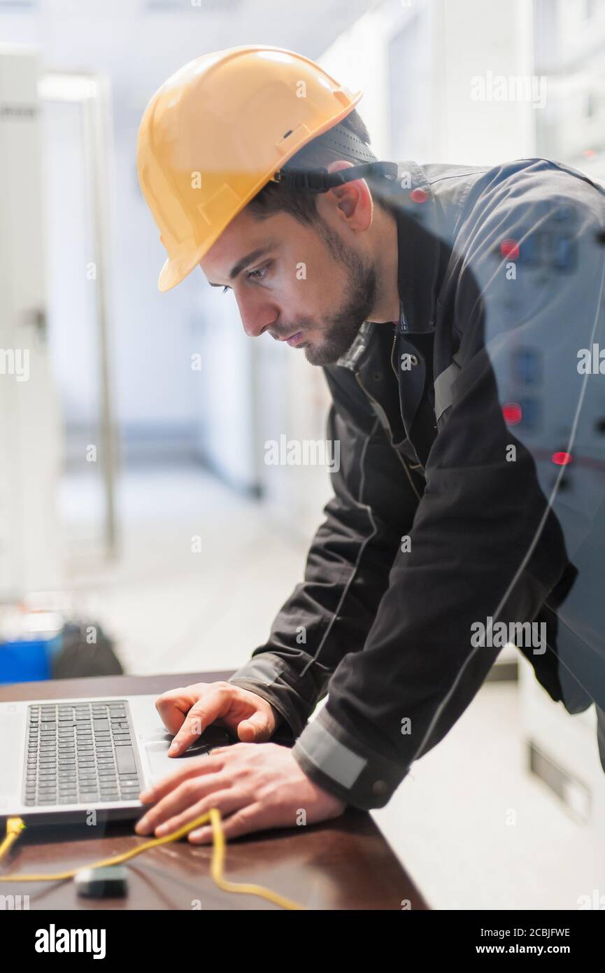 Maintenance engineer inspect relay protection system with laptop