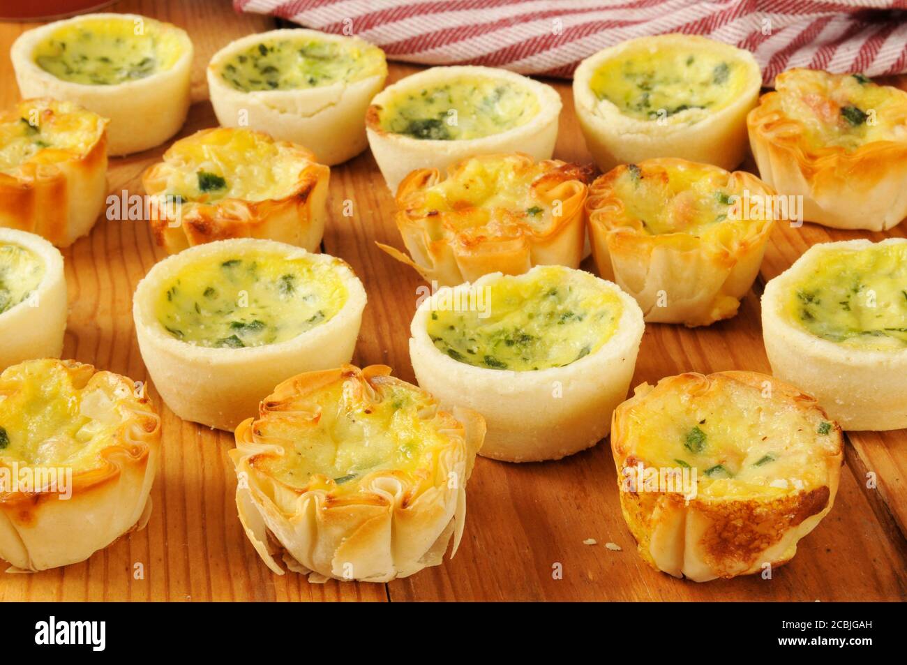 Quiche florentine and bacon quiche on a rustic wooden counter Stock