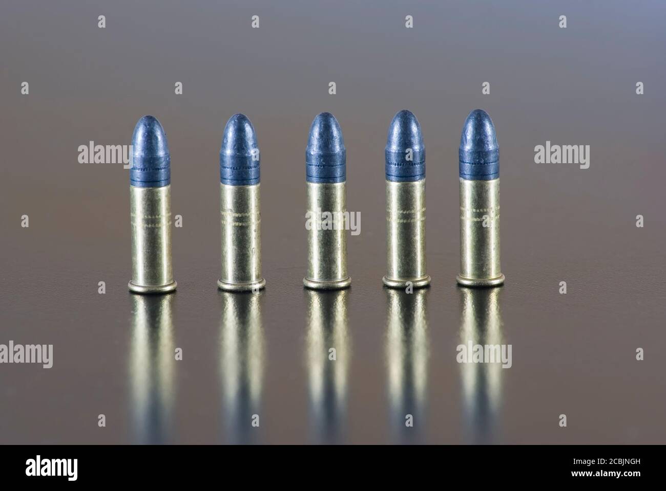 Five 22 long rifle rimfire cartridge on a table Stock Photo