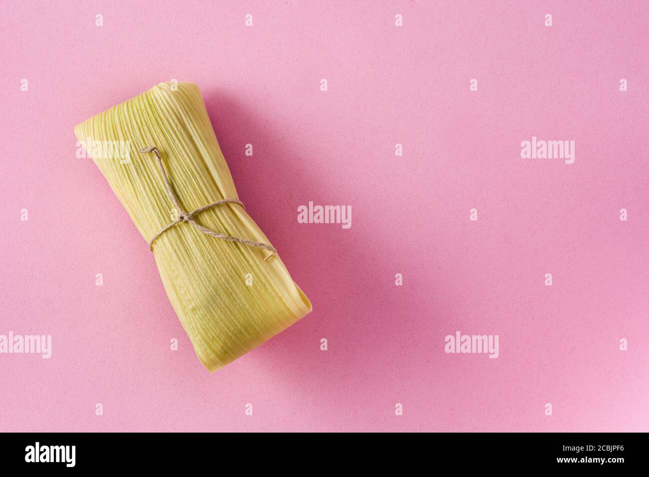 Mexican corn and chicken tamales on pink background Stock Photo